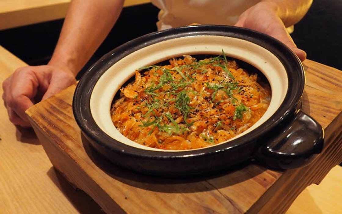 Sakura ebi rice is presented to diners before it is portioned out individually