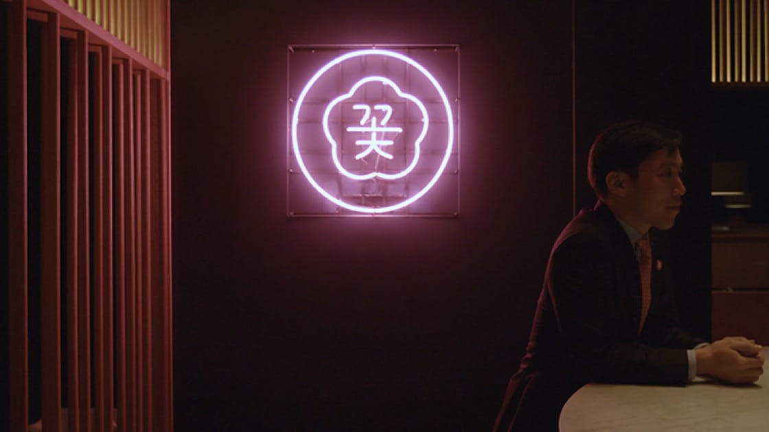 Cote owner Simon Kim in front of the restaurant's logo.