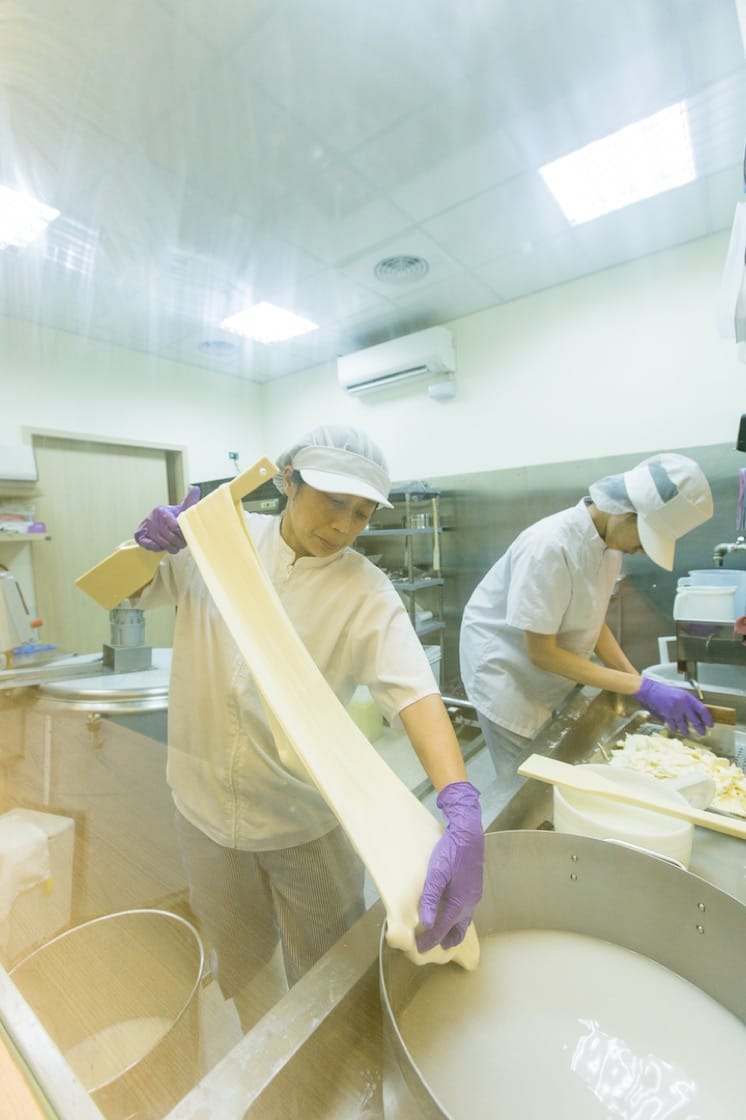 Chen pulls and stretches the curd in hot water of 95°C, kneading and shaping it like dough.