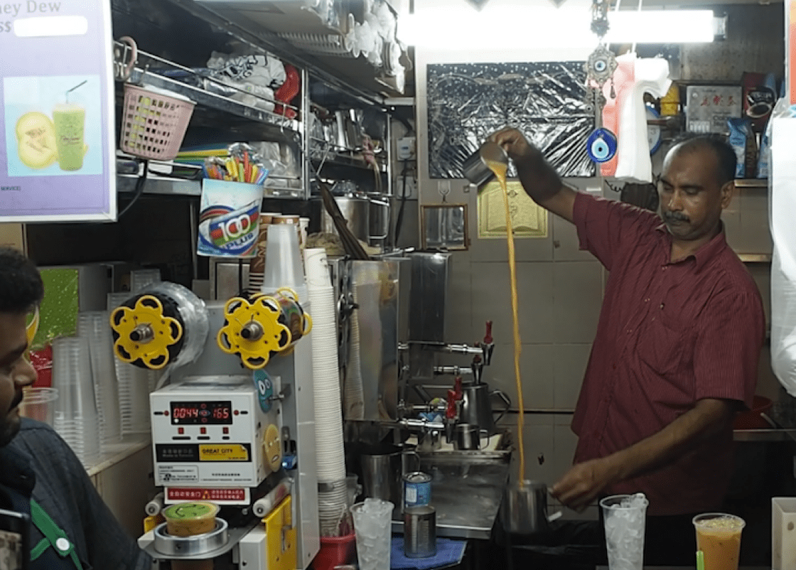 Owner Furkhan Ali shows the "pulling action" of making a teh tarik. (Credit: Kenneth Goh)