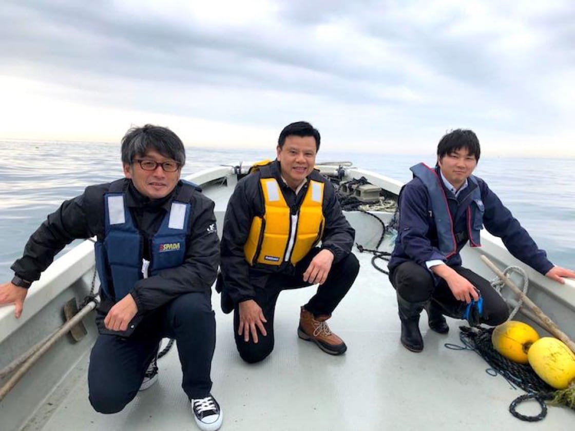 Chi (centre) with his partners from the Japan Fisheries Cooperatives out at sea.