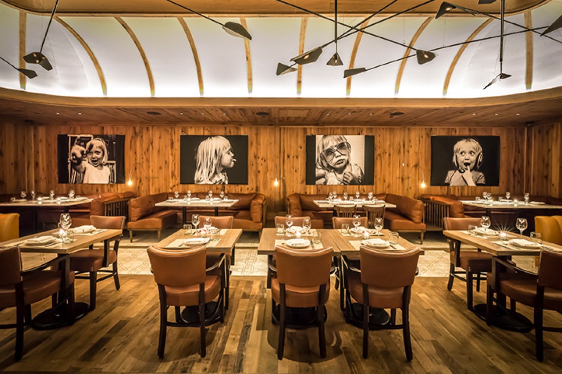 One of the dining rooms at Leuca is an "elegant nook fitted out with wood paneling and oversized black-and-white photographs," according to inspectors. (Photo by Noah Fecks.)