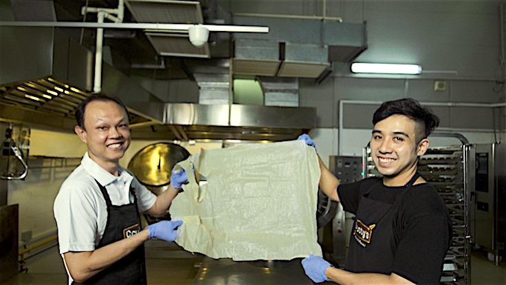 Operations head Kelvin Tan and production director Melvin Wong of Crusty's Singapore with a sheet of soybean skin (Photo: MICHELIN Guide Digital)