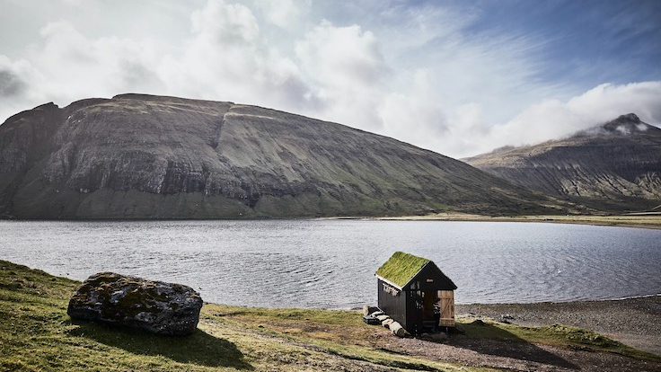 A hjallur, which is a wooden drying shed on wheels, is partially transformed to welcome guests before they embark on their journey to KOKS’s dining room.