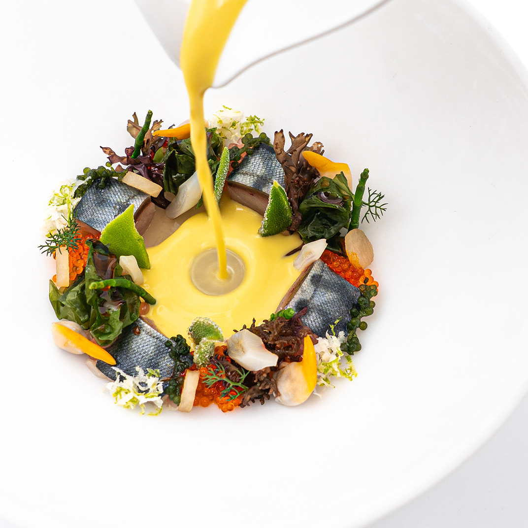 Caballa marinada con berberechos, navajas, algas y gazpachuelo de dendê, un plato de Cocina Hermanos Torres © Cocina Hermanos Torres