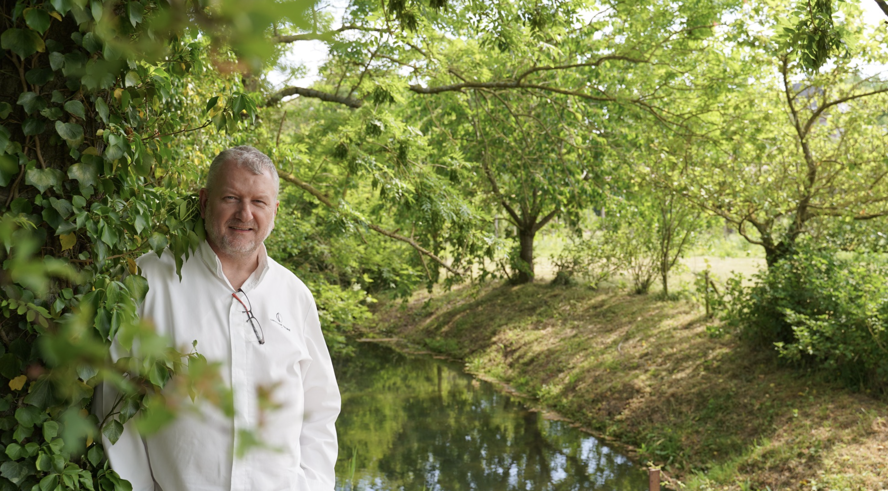 Le chef Christophe Dufossé posant auprès d'un saule pleureur © Tina Meyer