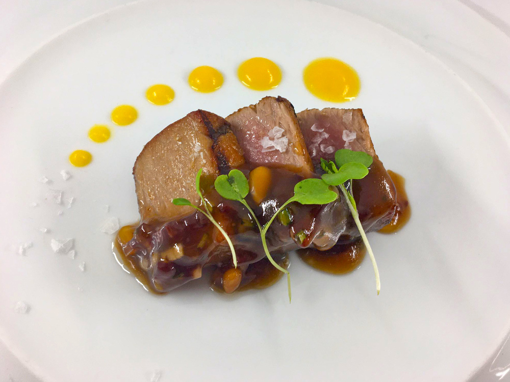 Lomo de atún a la brasa, con cebolla caramelizada y vinagreta de jamón ibérico y piñones. © La Cuchara de San Lorenzo