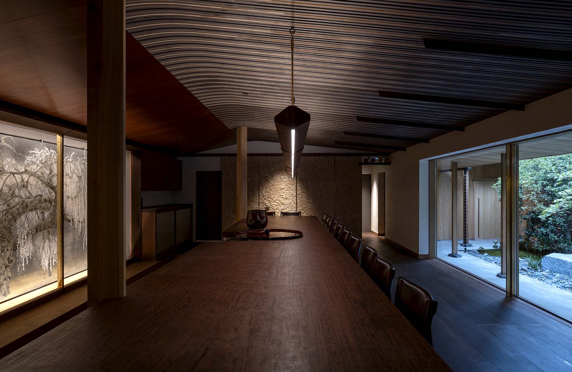 Bar Kun: antique fabric ceiling, fossil-studded stone wall, and soft light from the courtyard. © Akinobu Kawabe