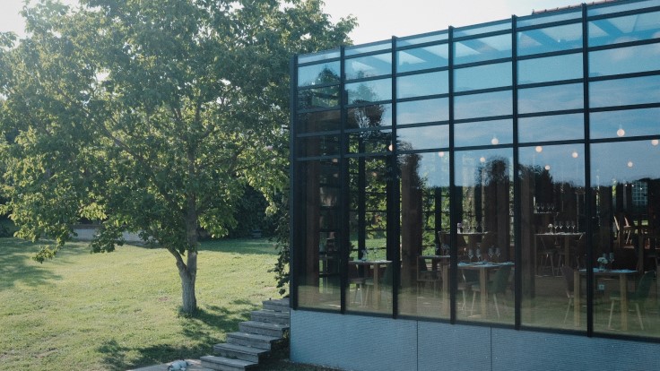 Pajta's glass-fronted exterior blends seamlessly into the surrounding landscape (© Pajta)