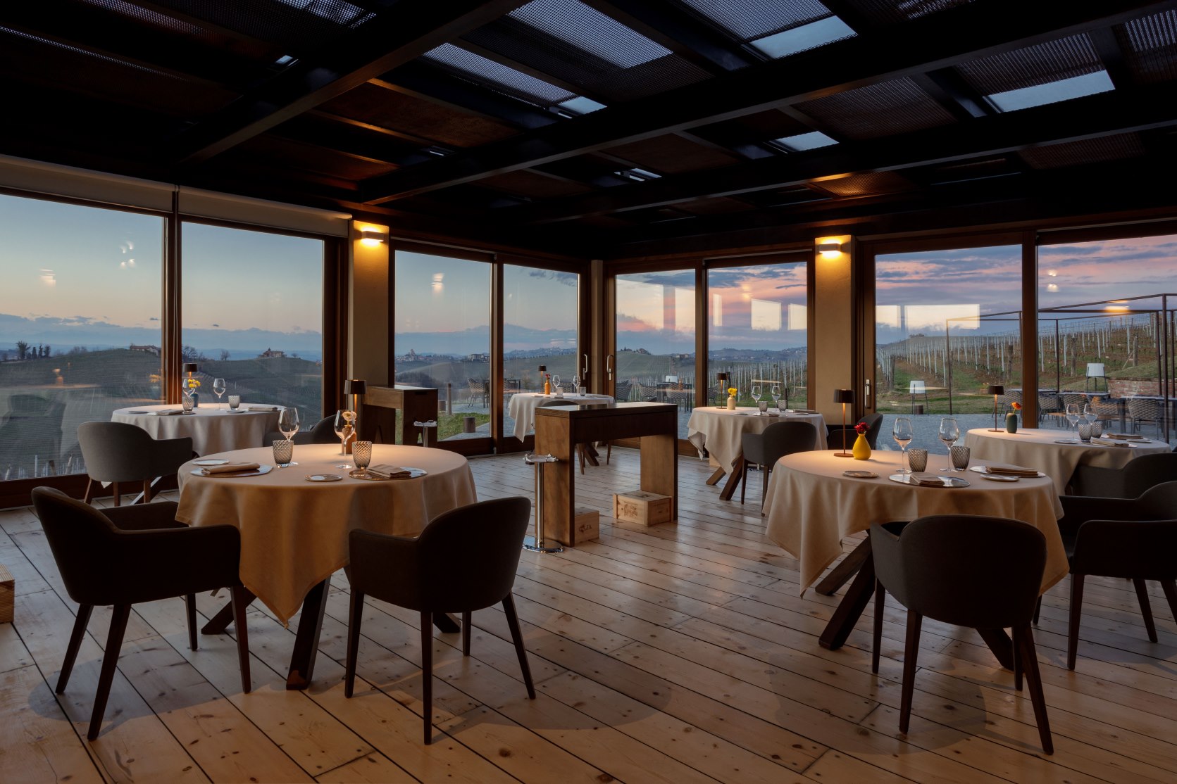 Ristorante Borgo Sant’Anna blends modern Piedmontese cuisine with stunning vineyard views through its glass-walled dining room in Langhe’s UNESCO region. © Borgo Sant'Anna