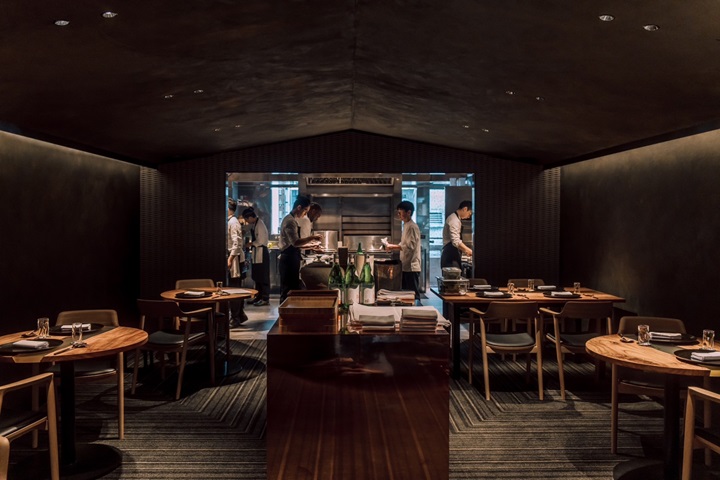 The dining area features an open kitchen at the far end serving as both the visual and experiential centerpiece and spotlight. (©Li Yu Chu Co., Ltd.)