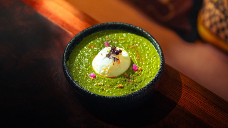 This version of Saag made with fresh burrata cheese with garlic tempered spinach, pickled onions is a modern twist on a classic Indian favorite. Image credit: Pincode