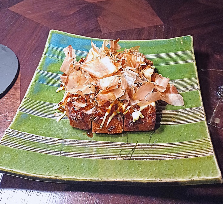 A milky crispy Japanese toast is topped with lightly minced prawns and bonito flakes. Image credit: The MICHELIN Guide