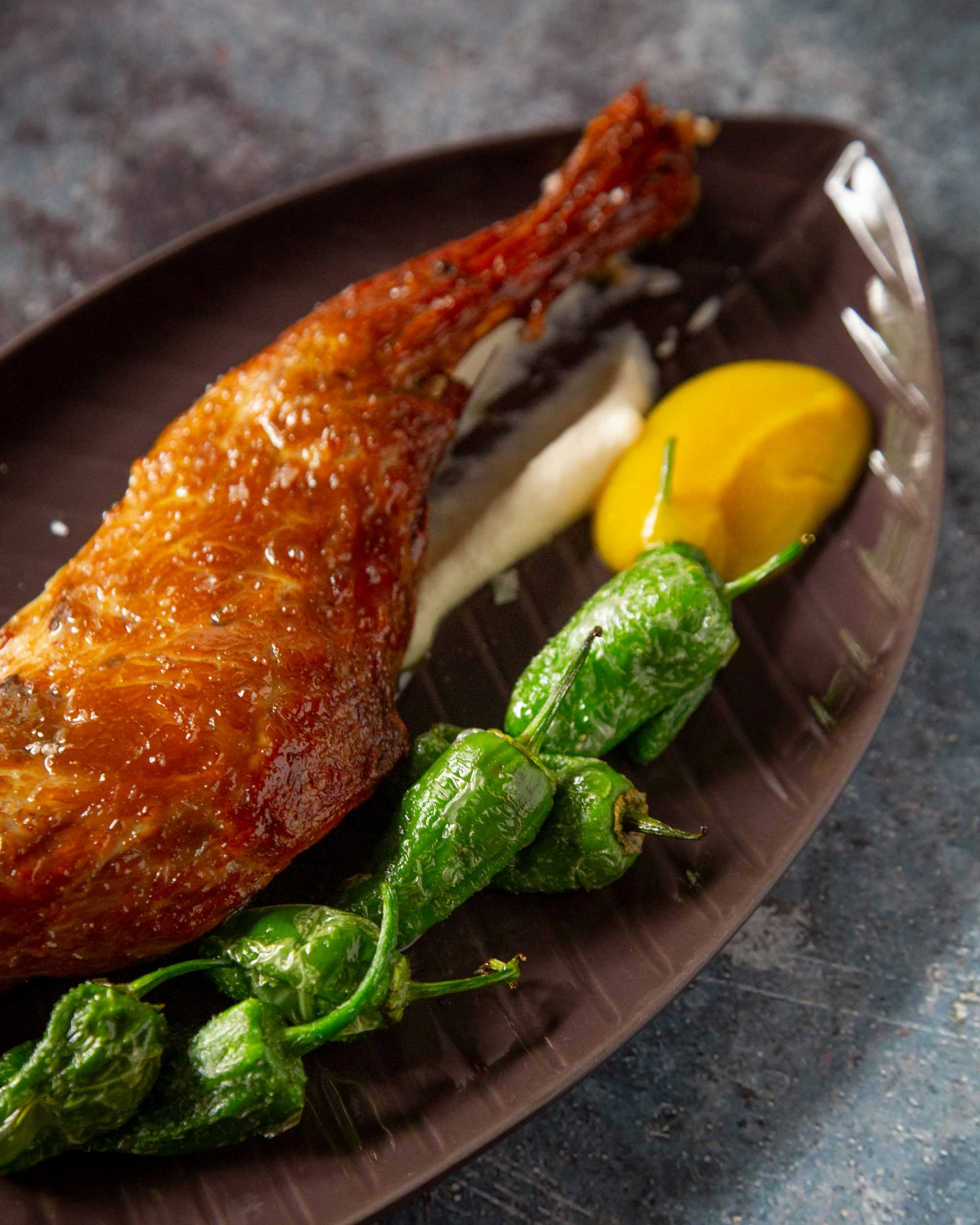 ¿Un clásico de la casa? Prueba su jugosa Paletilla de cordero asada, servida sobre crema de coliflor al ajillo, manzana asada y pimientos fritos. © Granero