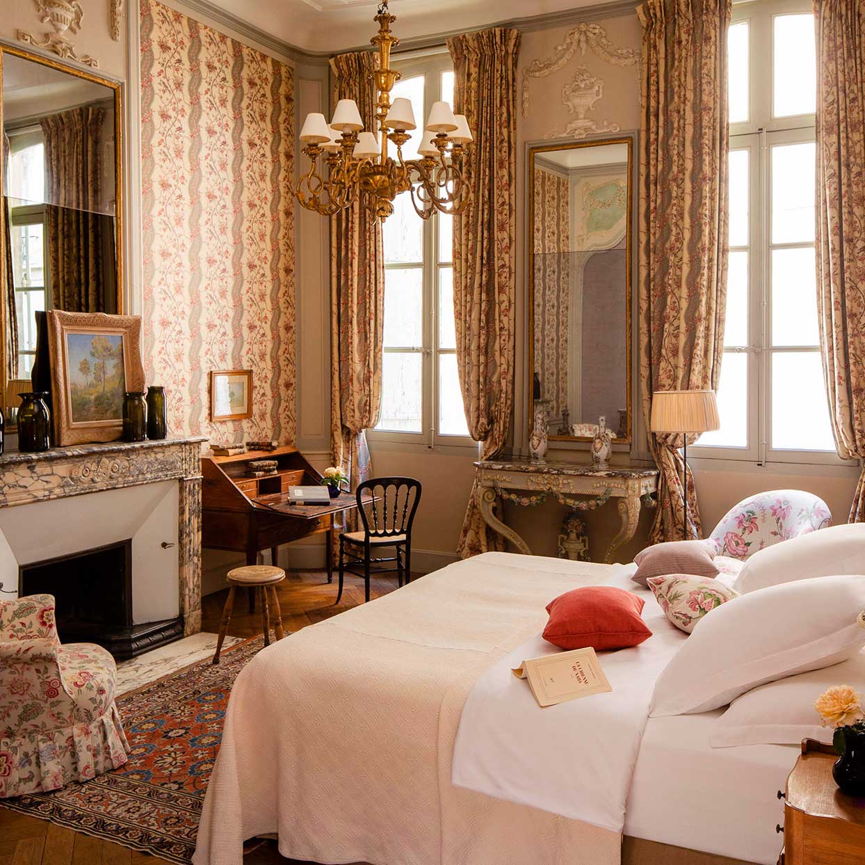 Another of La Mirande’s 26 distinctive bedrooms, where period furniture and printed fabrics evoke a bygone era. © La Mirande