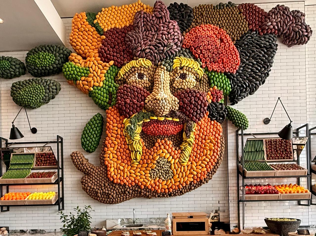 A fresh produce sculpture resembling Poseidon hangs on the wall in the fresh fruit and vegetable section of the hotel's breakfast dining area. Image credit: Kelly Sadek