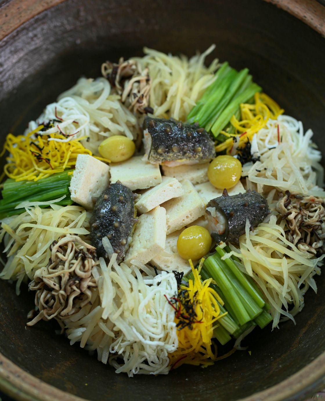 Onjium's tofu hotpot layers white tofu with golden seasonal ingredients, evoking the colors of autumn. Mushrooms bring the fragrance of the forest to each spoonful. ©Onjium 