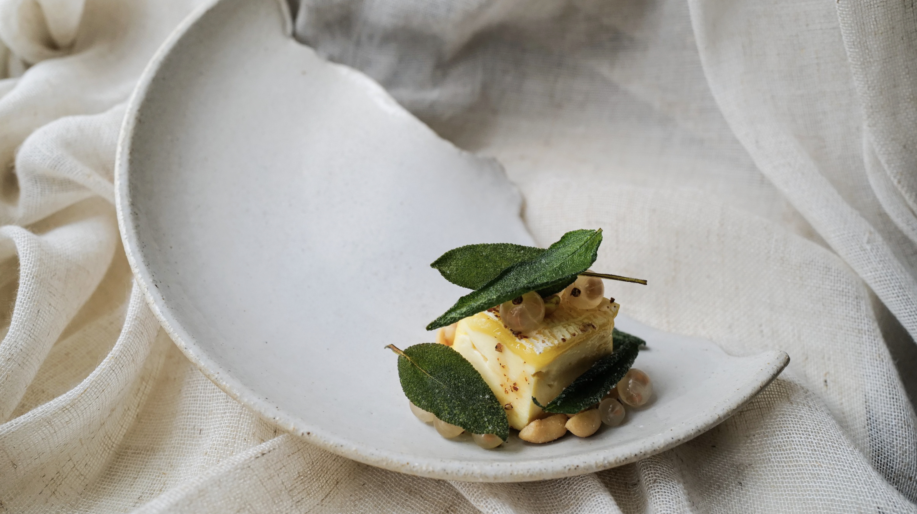 Le petit Troo, cacahuètes caramélisées au miel de sarrasin, sauge et groseilles blanches, servi chez Osma. Assiette en céramique de l'artisan Michael Buckley © Justine Vioche