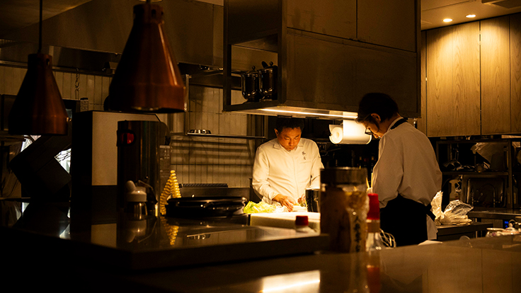 飄香の客席から厨房を望む。井桁シェフと共に仕込みをするスタッフ　 © Hisashi Yoshino / The MICHELIN Guide