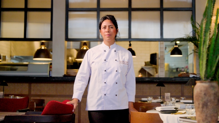 Chef Nihal Felemban stands in front of the semi-open kitchen of The Lucky Llama, located in Jeddah. © Michelin
