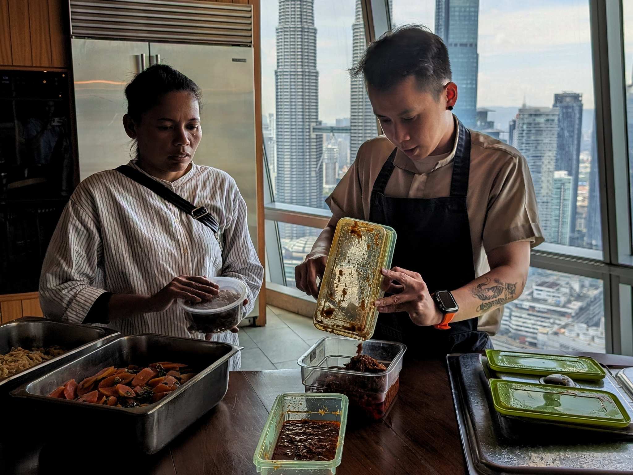 Salmiah (left), portions out the meal together with Wong. © Ethan Lau