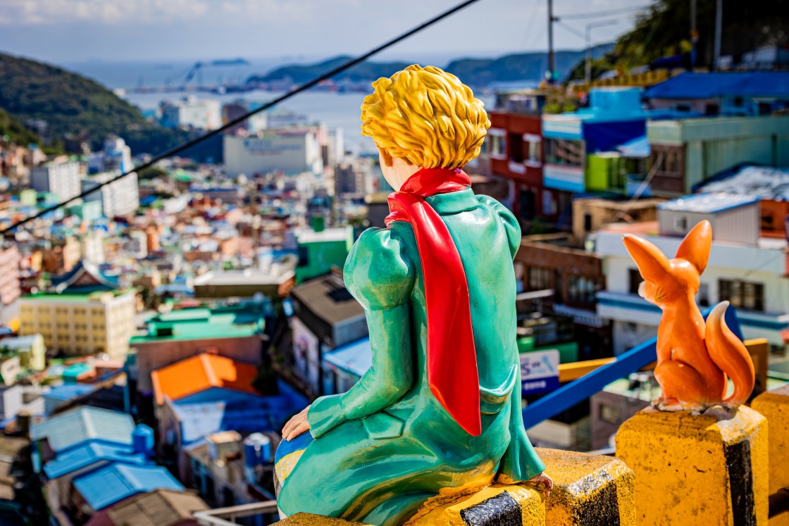 The Little Prince and Fox overlook a sea of rooftops — a beloved viewpoint symbolizing the imaginative spirit threading through Gamcheon Culture Village. © Kuba Puchajda/Shutterstock