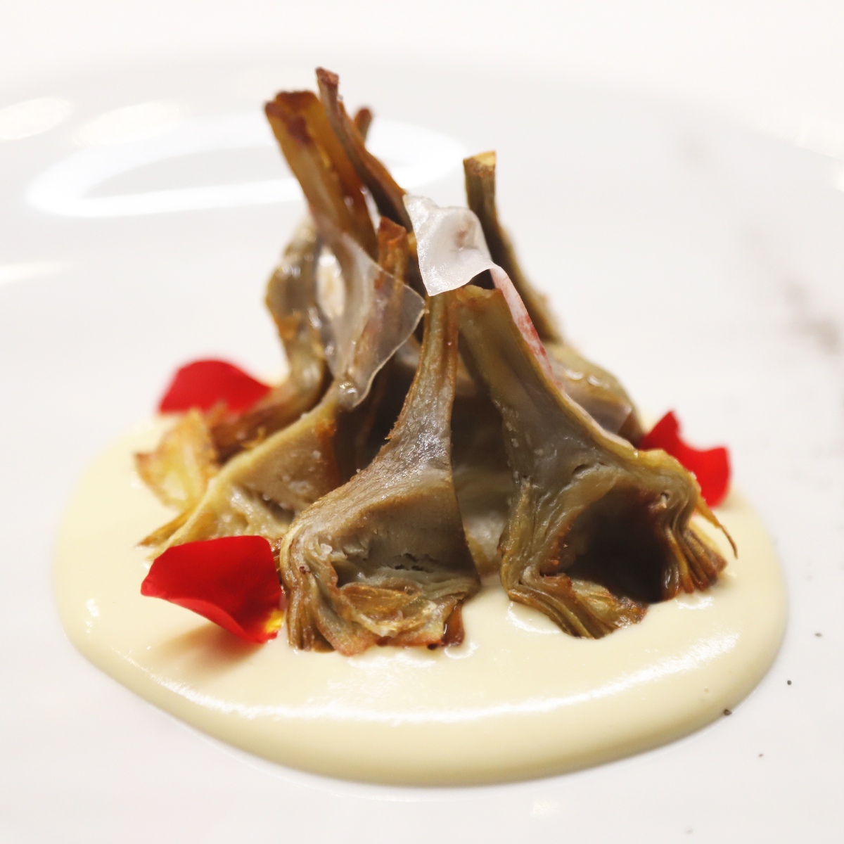 Alcachofas fritas sobre coulis de ajo y velo de papada ibérica, uno de los platos de la sección ¡Arriba la cuchara y la huerta! © Fotos Rodríguez/Morro Tango