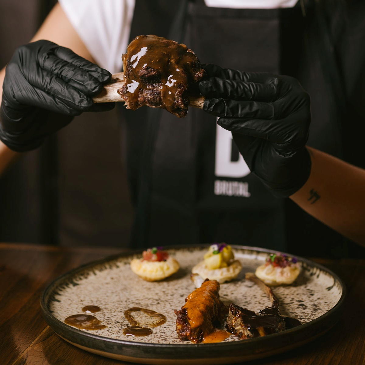 La Costilla Brutal, the signature dish of Brutal, is served with gloves for those who want to enjoy it with their hands. © Brutal
