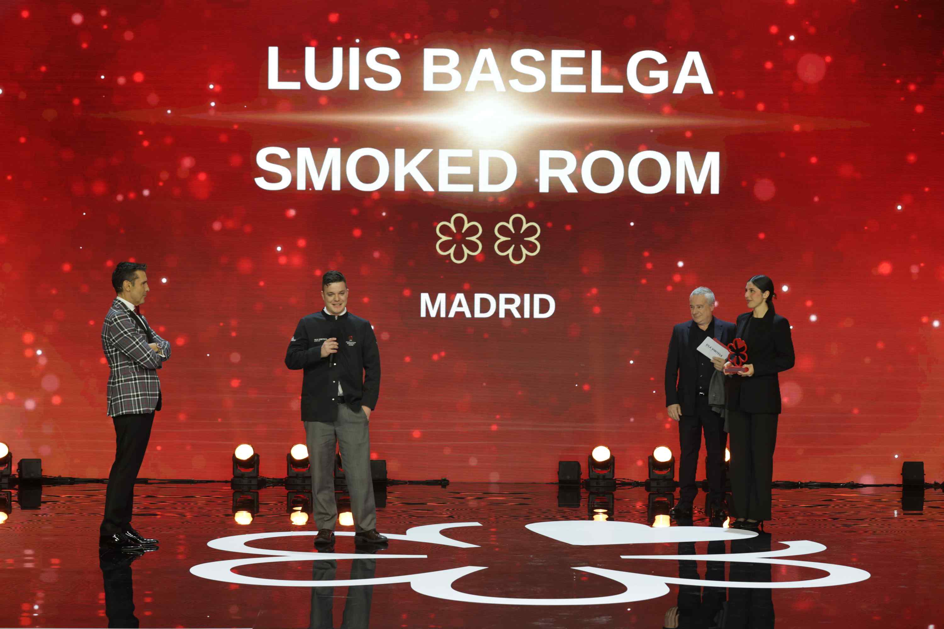 Luis Baselga recogiendo el Premio MICHELIN al Sommelier en la Gala de la Guía MICHELIN en Málaga, junto al presentador Jesús Vázquez y Quim Vila, de Vila Viniteca. © MICHELIN