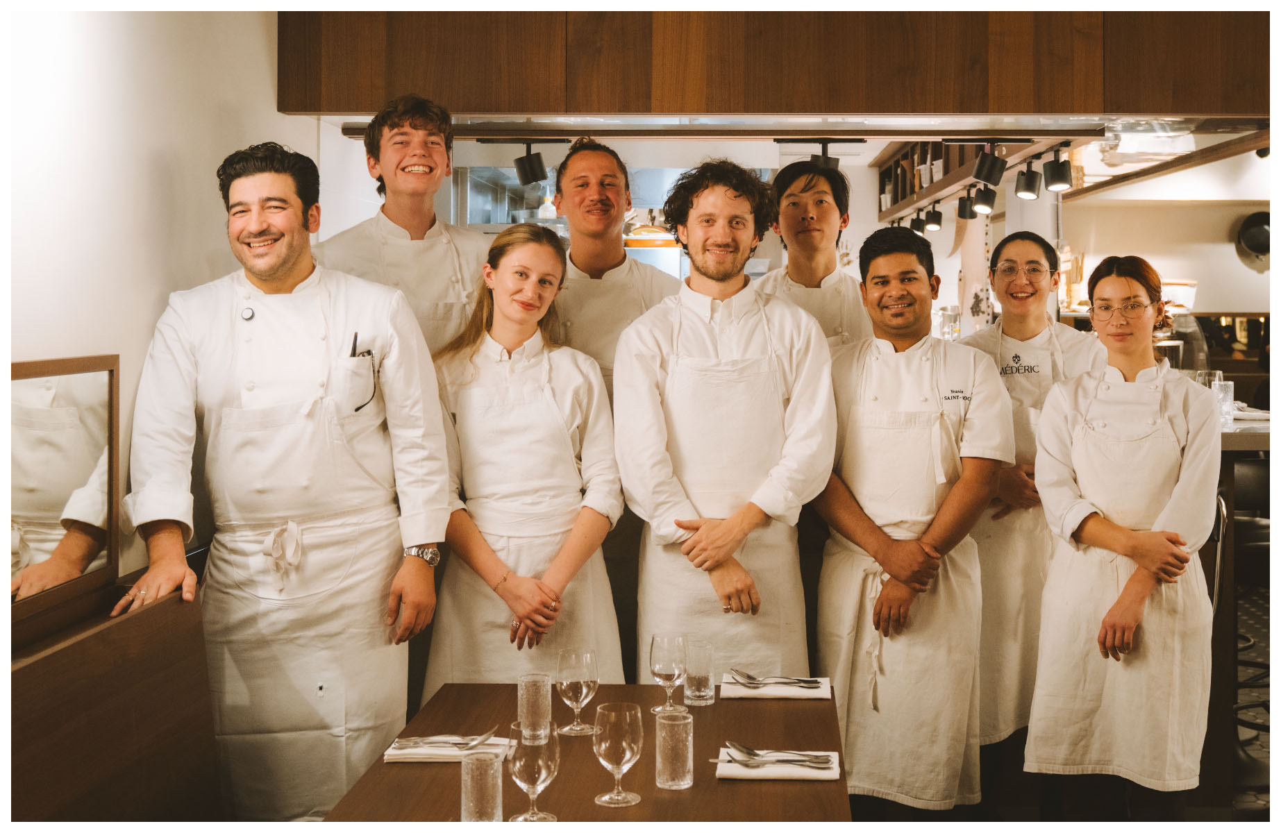 The team at 19 Saint-Roch bistro and Chef Pierre Touitou posing in front of their open kitchen. © Joann Pai/The MICHELIN Guide