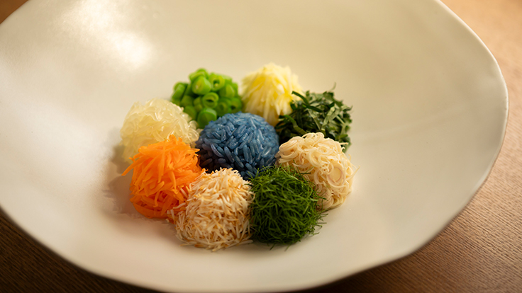 お客様を華やかにお迎えしたいという想いから最初に出す料理「カオヤム」。人参、いんげん、干し海老、マンゴーなどが入る、青いジャスミンライスのサラダ  © Hisashi Yoshino / the MICHELIN Guide