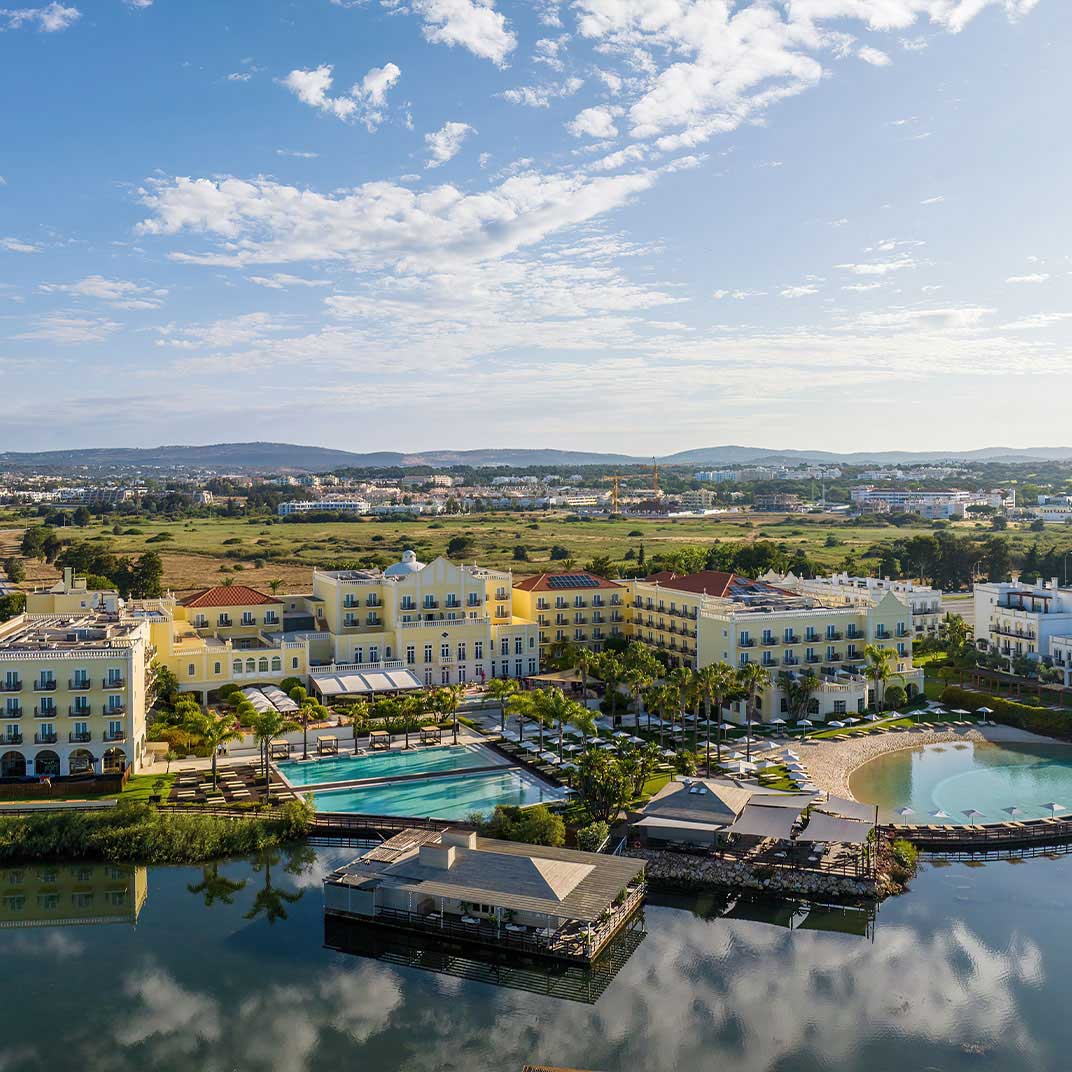 Domes Lake Algarve sprawls across Portugal’s southern coast in Vilamoura, where colorful Mediterranean architecture surrounds a private lake near both harbor and beach. © Domes Lake Algarve  