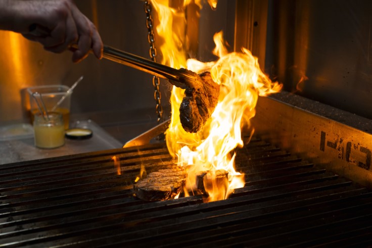 A chef cooking over an open flame in the kitchen (© VÕIVÕI).