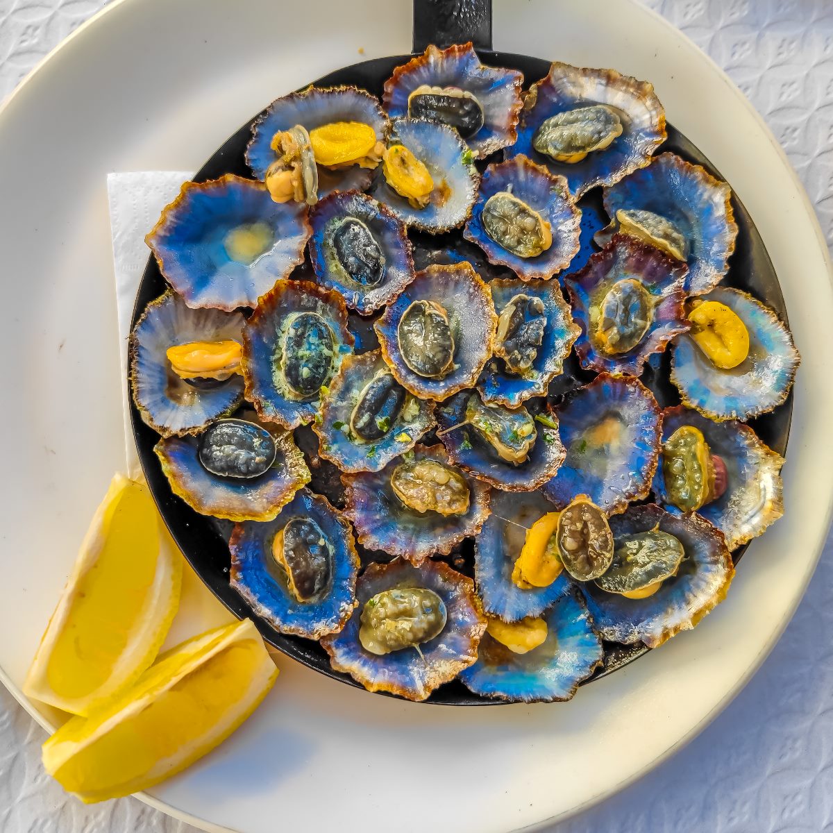Se há um marisco que brilha na ilha da Madeira, esse marisco é a lapa, geralmente grelhada com alho, manteiga, salsa e limão. © Audrius Venclova/iStock