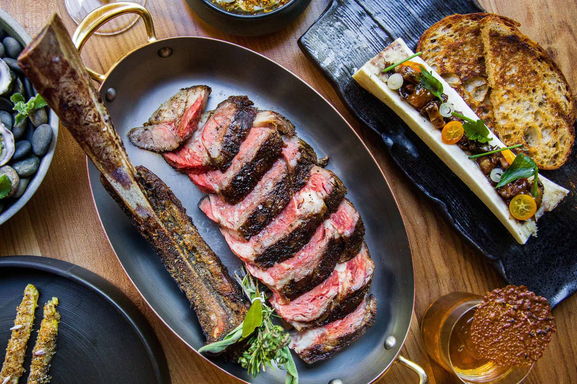 Niku's ultra-luxe setting is echoed by a decadent spread comprising tomahawk steak, bone marrow and other delicious options. © Allie Tong/Niku Steakhouse