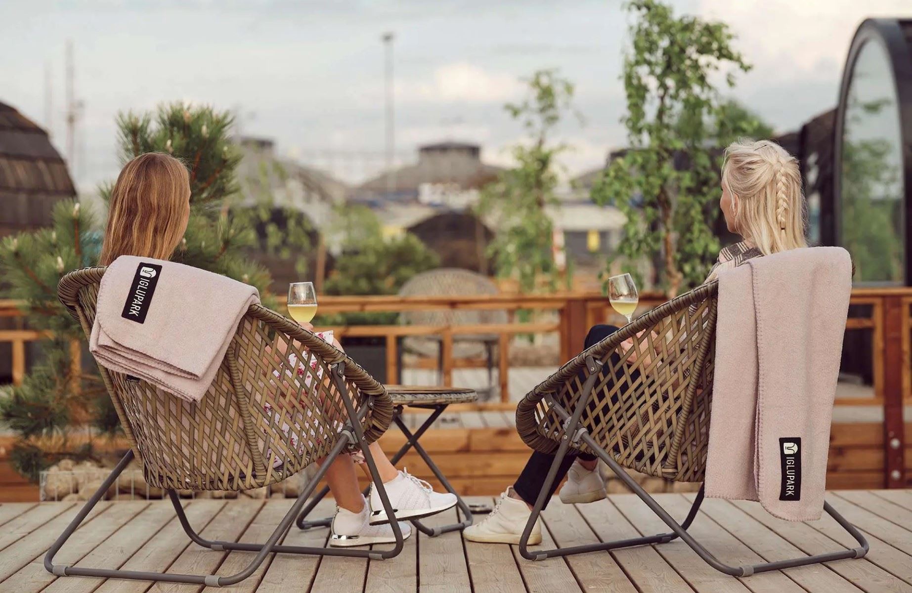 Two guests relaxing with a glass of wine on an Iglupark terrace. © Iglupark