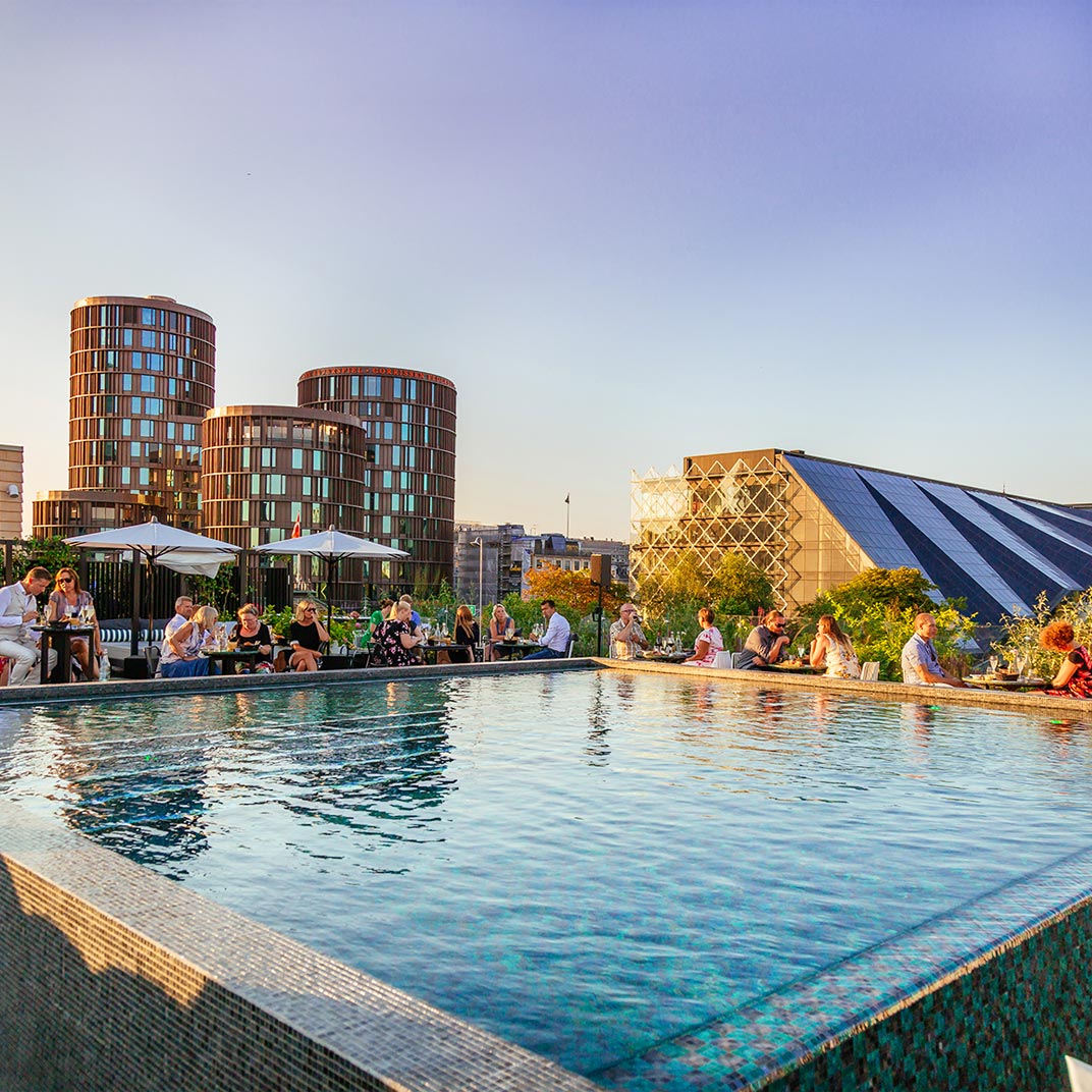 The emerald rooftop pool sits directly above Tivoli Gardens, Copenhagen’s oldest amusement park. © Nimb 