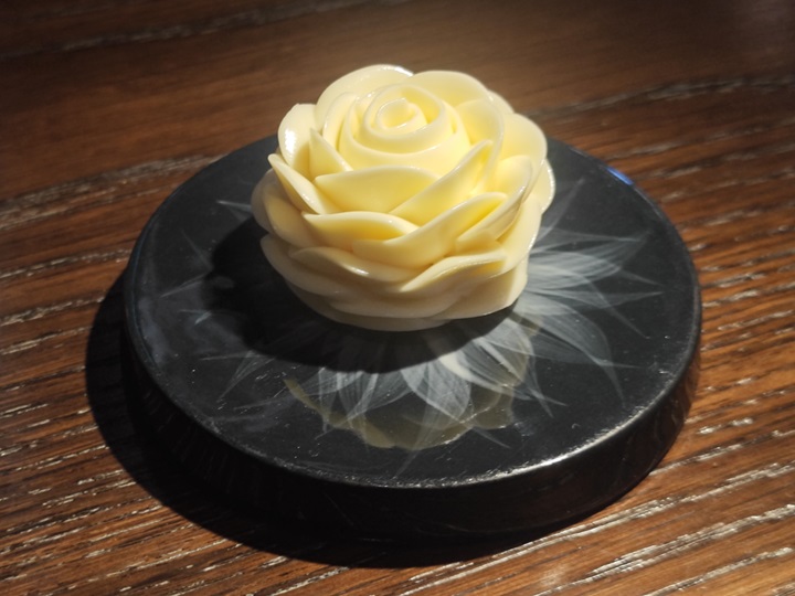 The butter served with bread, shaped like a rose, is lightly infused with beer. © MICHELIN
