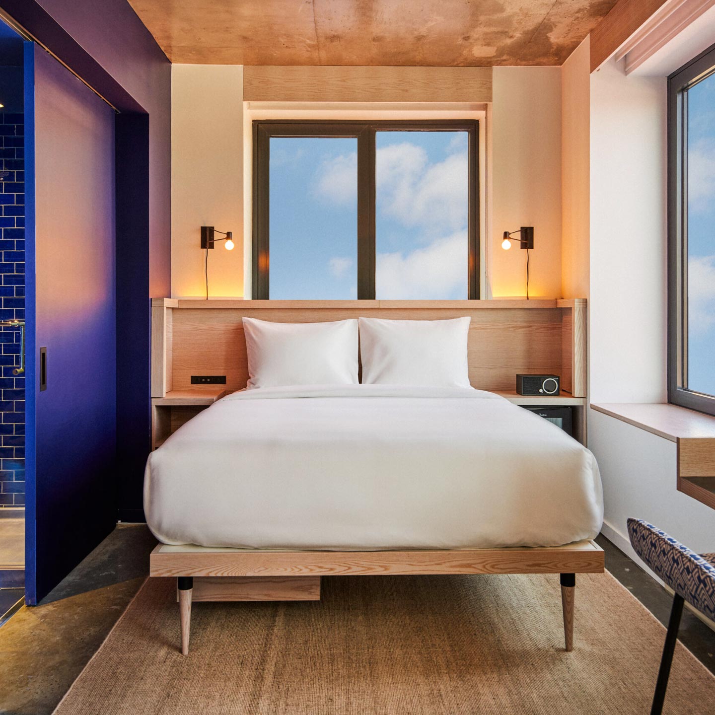 A minimalist, view-forward design in a deluxe queen, with the hotel's typically brightly colored bathroom.  © Radio Hotel