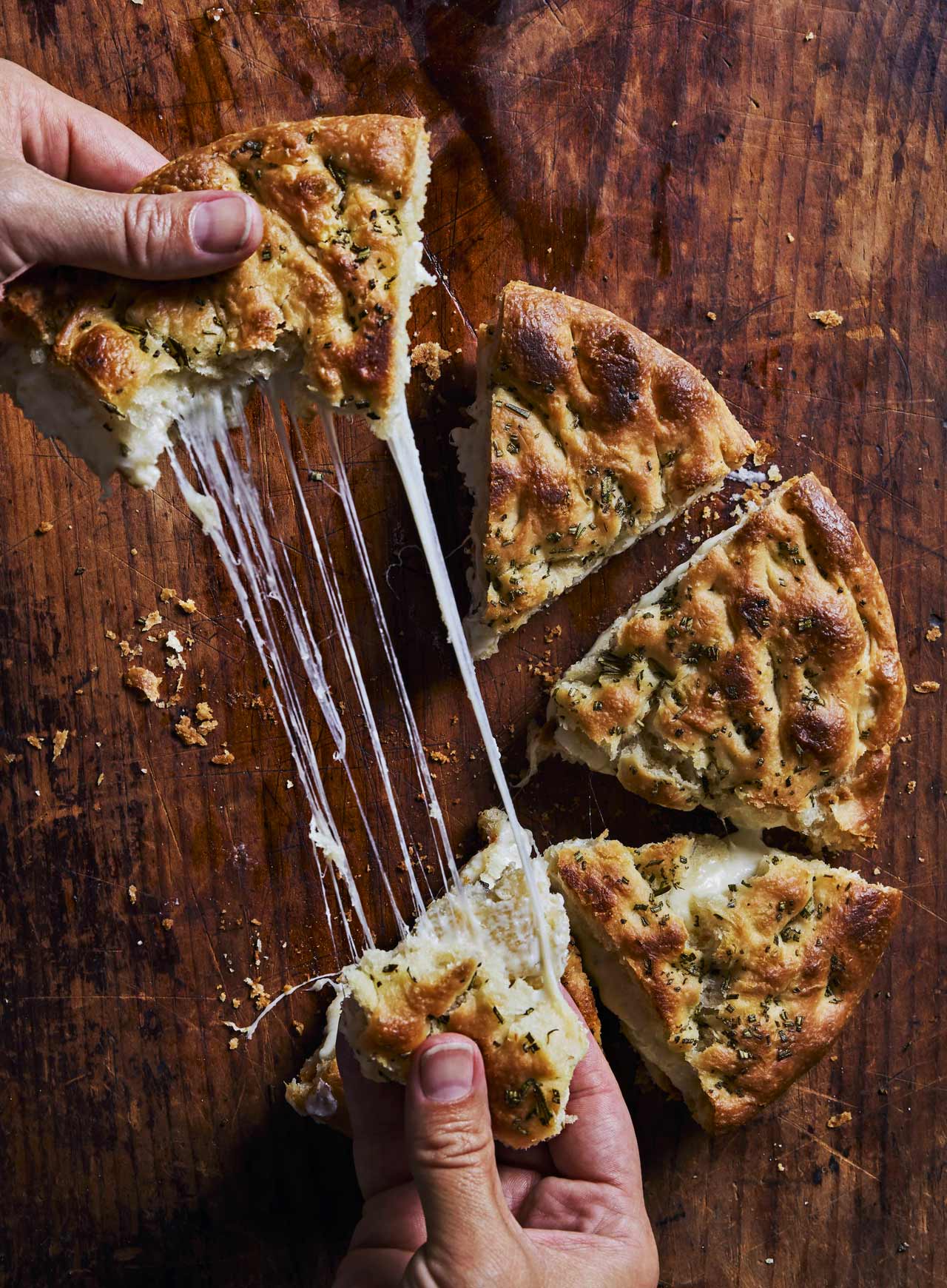 Crusty golden focaccia is pressed with rosemary and filled with cheese at Fox & The Knife. © Kristen Teig/Fox & The Knife