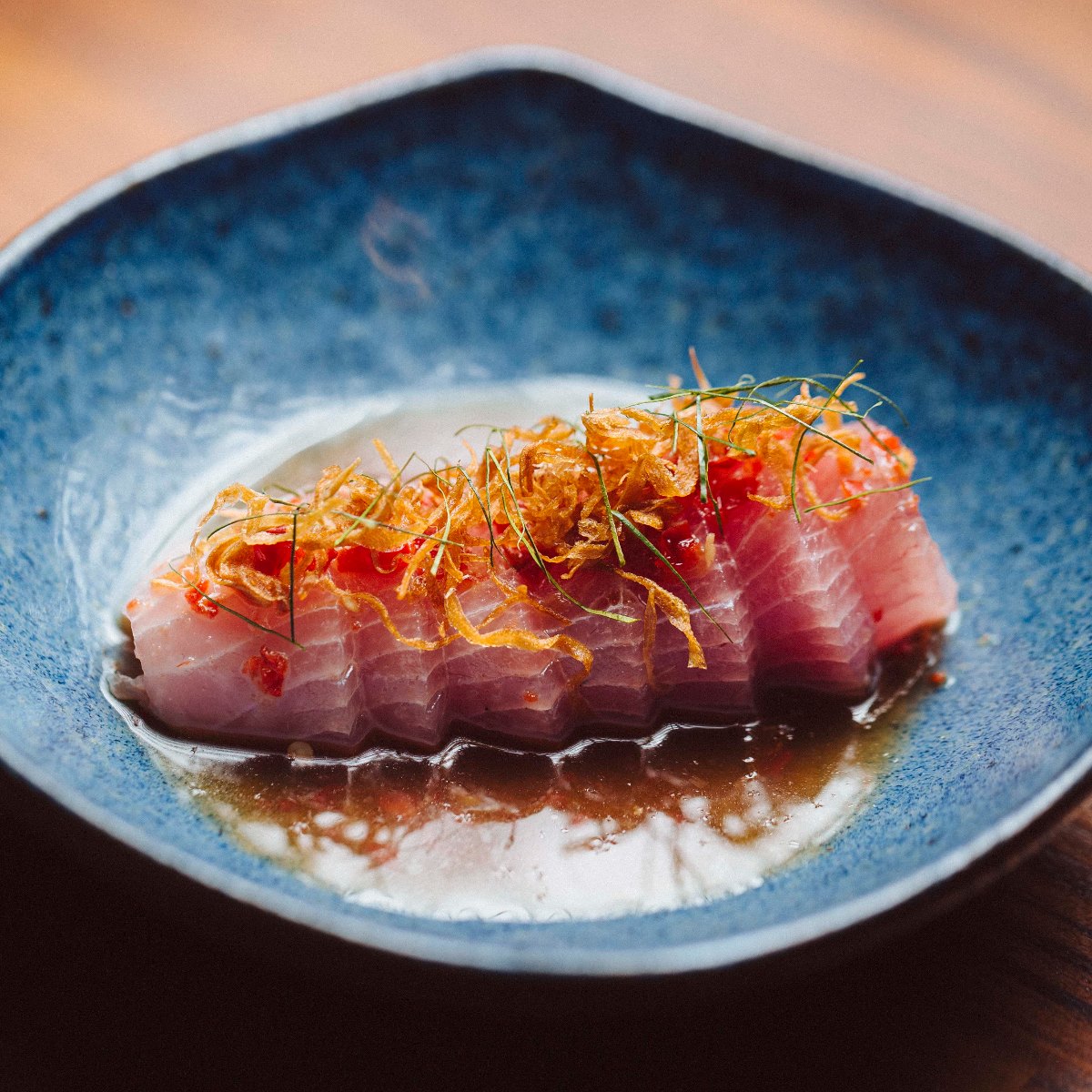 O Pla dip, prato confeccionado com peixe do dia, molho nahm jim taleh, crisp de cebola e folha de limão makrut, do restaurante paulistano tailandês Ping Yang Thai. © Pedro Ferrarezzi/Ping Yang Thai