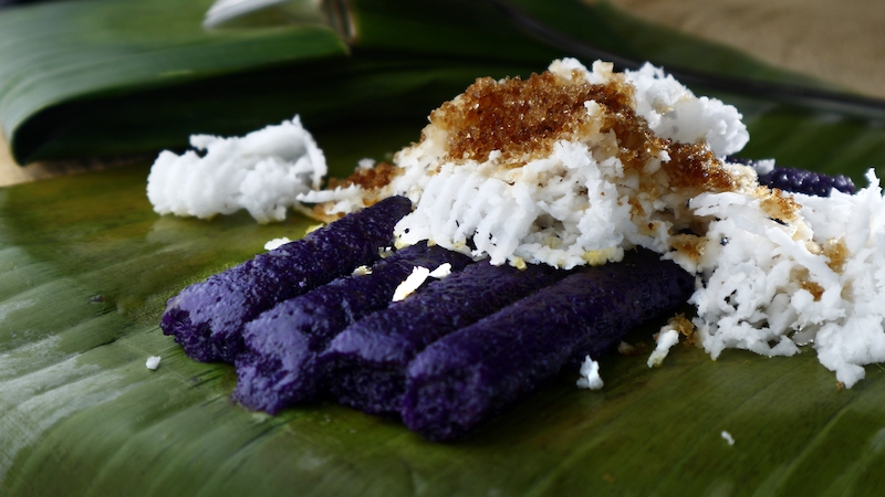 In the Philippines, Christmas dawn masses are marked by warm puto bumbong — steamed black rice in bamboo, finished with butter, coconut, cheese, sugar and latik. © Jun Pinzon
