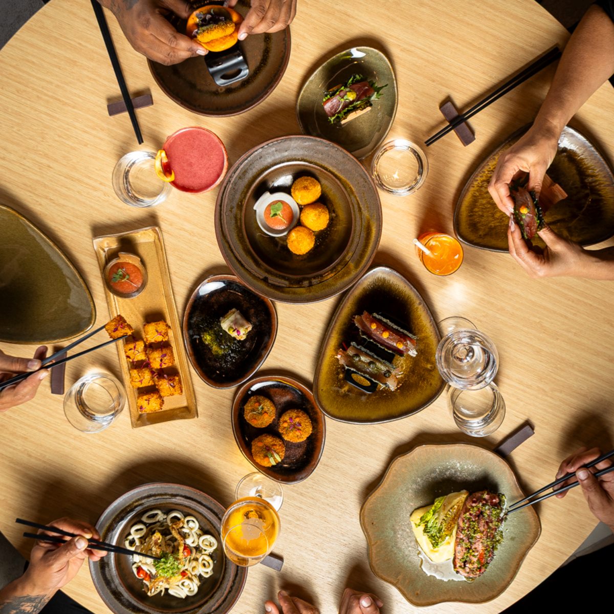 A convidativa mesa do Kureiji, novo restaurante Recomendado em São Paulo, apresenta preparações com técnicas japonesas e produtos brasileiros, como o Ika okinawa soba, o Sashimi crocante e o Batera sushi. © Kureiji