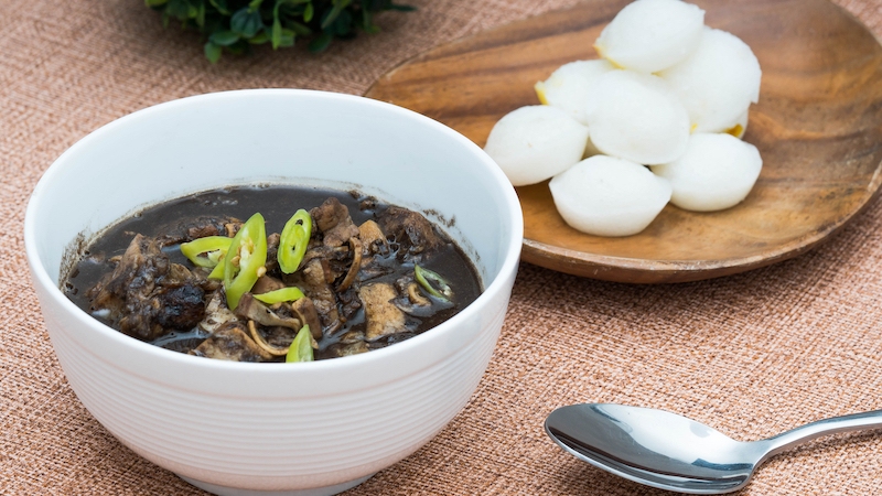 Dinuguan, a rich pork and offal stew simmered in blood and spices, finds balance in soft rice cakes that temper its depth and invite another bite. © Richard Ernest Yap