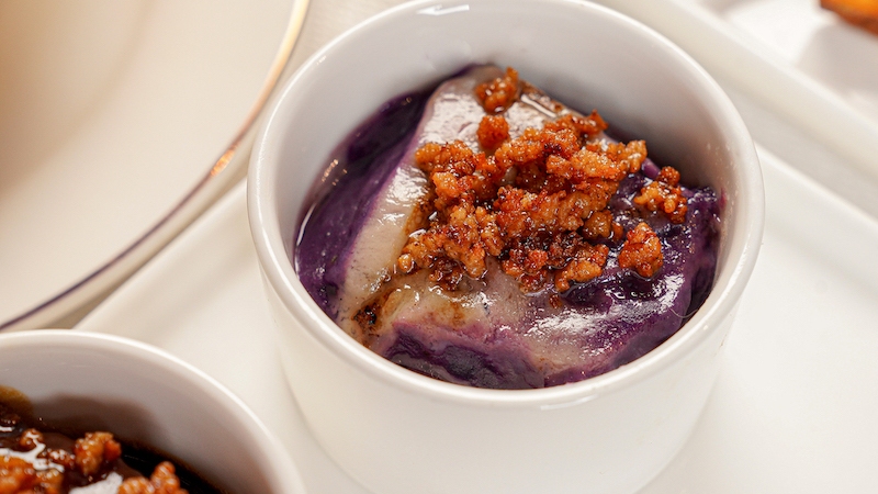 Inutak, a Pateros delicacy served in shallow trays, is a layered ube rice cake with a charred, crinkled top — rich, flan-like and cut with coconut cream. © Cabel