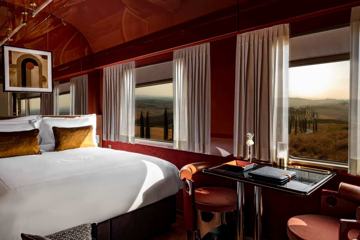 Una suite en La Dolce Vita Orient Express y las grandes vistas del paisaje toscano que se extienden a través de las ventanas. © Mr.Tripper