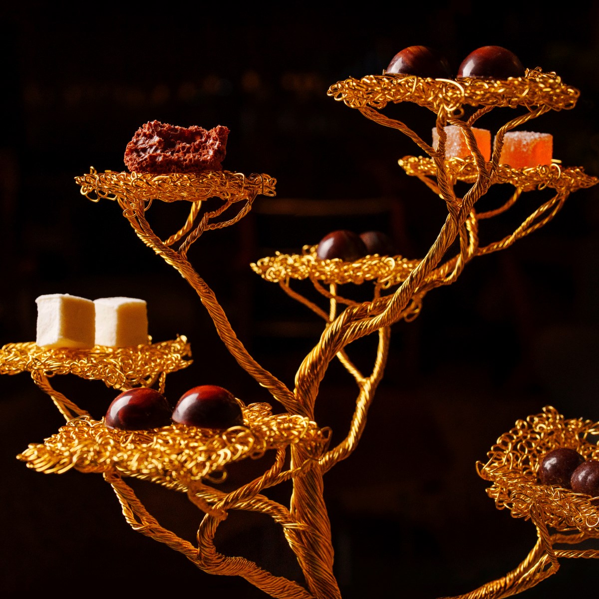 Alguns dos doces elaborados na cozinha do Tuju são apresentados em uma árvore artesanal feita com fios dourados. © Rubens Kato/Tuju