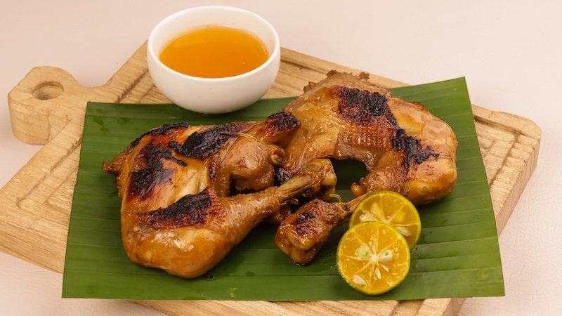 Chicken oil is the soul of inasal — golden-orange from atsuete, brushed onto the chicken as it grills and poured lavishly over rice for a rich, smoky savoriness. © Sri Widyowati