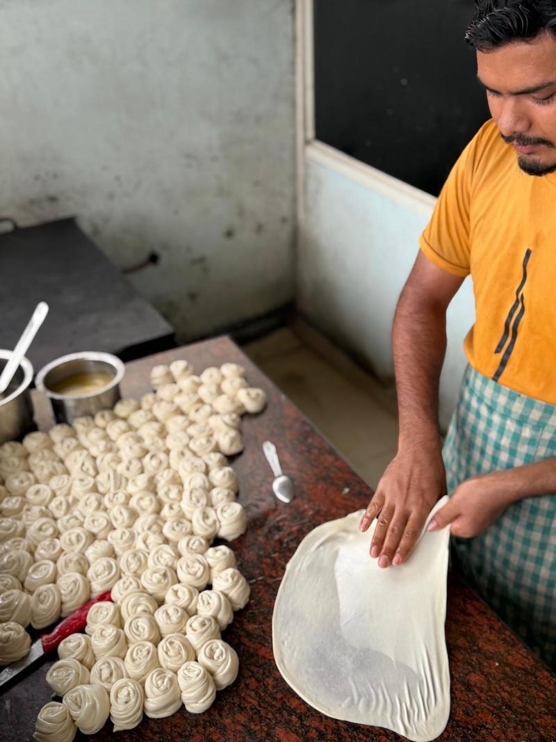 04 A man flips parotta. The action of flipping it thins the dough while trapping air.jpg