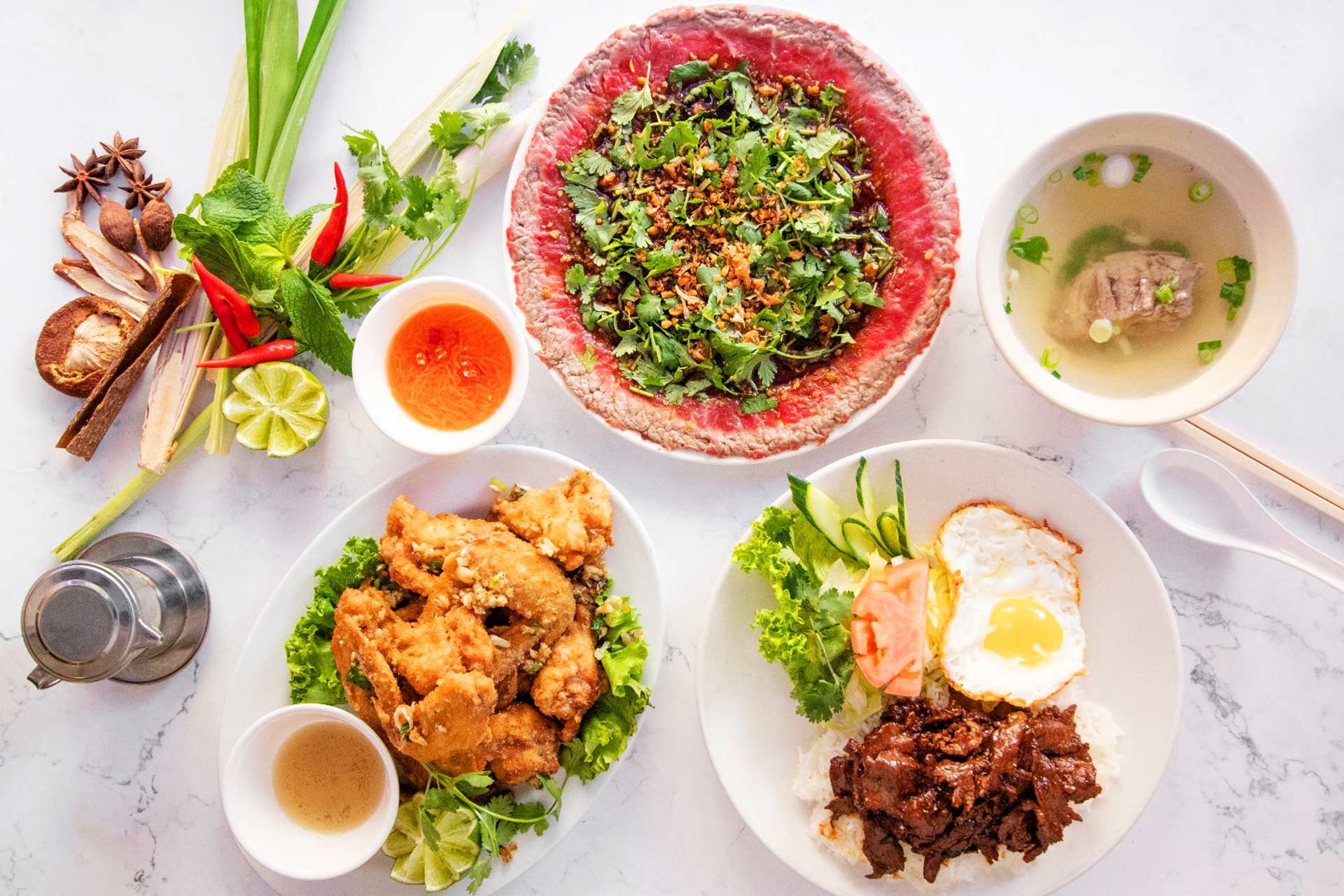 A spread including their butter beef and crispy chicken wings at Phnom Penh © Phnom Penh